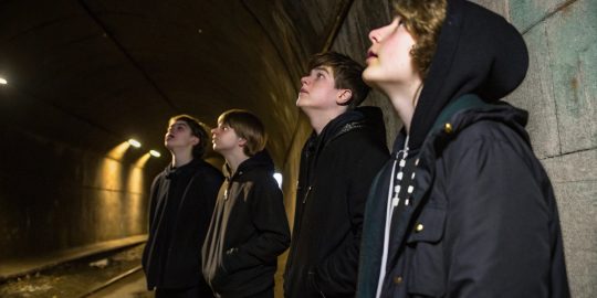 several-teenagers-in-dark-clothing-stand-in-the-tu